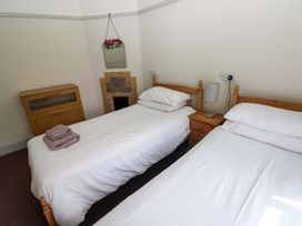 A bedroom with twin beds and a nightstand at White Thorns in Haverfordwest