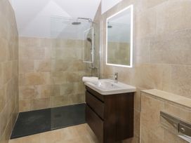 A bathroom with a walk-in shower a sink with a mirror and tiled walls at Winnie's Stable Goodmanham Wold near Market Weighton
