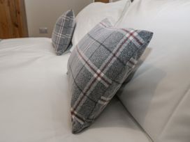 A close-up of two grey plaid pillows on a white sofa at The Groom's Cottage in Goodmanham Wold near Market Weighton