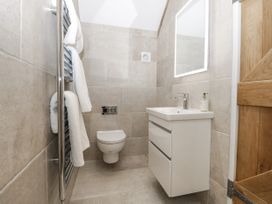 A small bathroom with a wall-mounted toilet sink cabinet mirror and towel rail at The Groom's Cottage Goodmanham Wold near Market Weighton