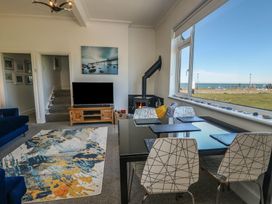 A living room with a tv and dining area at Little Orme View in Llandudno
