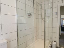 A shower enclosure with a showerhead and a toilet at Little Orme View in Llandudno