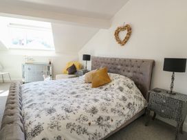 A bedroom with a bed and a side table at Little Orme View in Llandudno