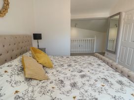 A bedroom with a bed and bedside lamp at Little Orme View in Llandudno