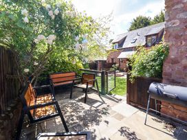 A garden area with chairs and a grill at The Linhay in Washford near Watchet