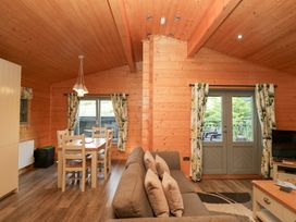 A living room with a sofa and dining area at Elm Lodge in Ulverston