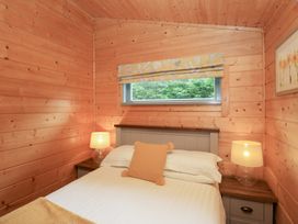 A bedroom with a bed and lamps at Elm Lodge in Ulverston