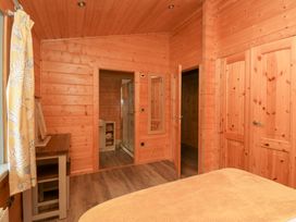 A bedroom with a bed and a table at Elm Lodge in Ulverston