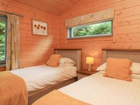 A bedroom with two beds and a window at Elm Lodge in Ulverston