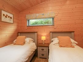 A bedroom with twin beds and a bedside table at Elm Lodge in Ulverston