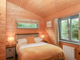 A bedroom with a bed and window at Elm Lodge in Ulverston