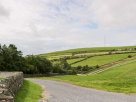 A landscape with a winding road, hills, and a telecommunications tower at Elm Lodge in Ulverston