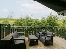 An outdoor seating area with chairs and a table at Elm Lodge in Ulverston
