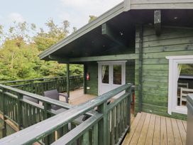 An outdoor area with deck, seating and windows at Elm Lodge in Ulverston