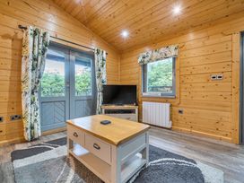 A living room with a television and a coffee table at Elm Lodge in Ulverston