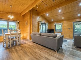 A living room with a sofa and dining table at Elm Lodge in Ulverston