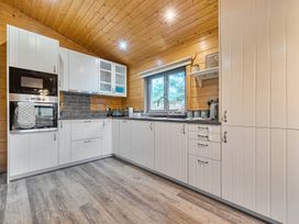 A kitchen with cabinets and appliances at Elm Lodge in Ulverston