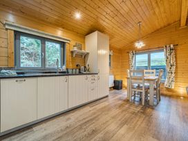 A kitchen with cabinets and a table at Elm Lodge in Ulverston