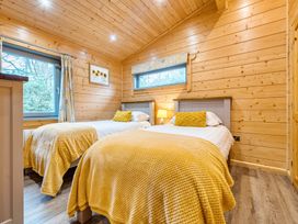 A bedroom with two beds and a window at Elm Lodge in Ulverston