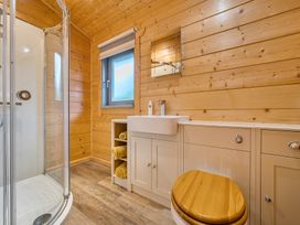 A bathroom with shower, sink, and cabinet at Elm Lodge in Ulverston