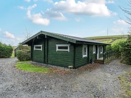 A cabin with a deck and gravel area at Elm Lodge in Ulverston