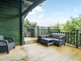 A balcony with a hot tub and seating area at Elm Lodge in Ulverston