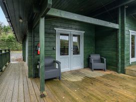 An outdoor area with chairs and a front door at Elm Lodge in Ulverston