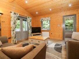 A living room with a sofa and television at Elm Lodge in Ulverston