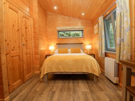 A bedroom with a bed and wardrobe at Elm Lodge in Ulverston