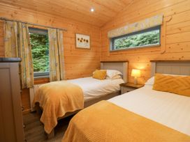 A bedroom with two beds and a lamp at Elm Lodge in Ulverston