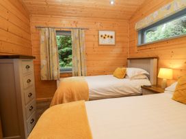 A bedroom with two beds and a window at Elm Lodge in Ulverston