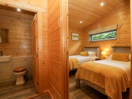 A bedroom with twin beds and attached bathroom at Elm Lodge in Ulverston