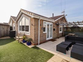 A house with a garden and outdoor seating at Sunrise Cottage in Beadnell