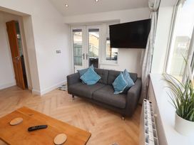 A living room with a sofa and television at Sunrise Cottage in Beadnell