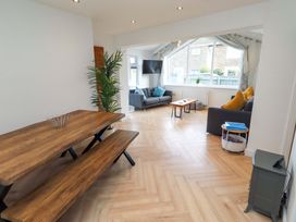A living room with a dining table and benches at Sunrise Cottage in Beadnell