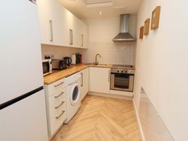A kitchen with appliances including a washing machine and a refrigerator at Sunrise Cottage Beadnell