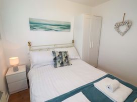 A bedroom with a bed and wardrobe at Sunrise Cottage Beadnell