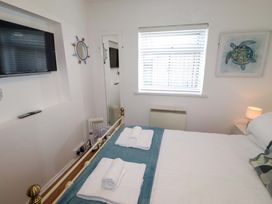 A bedroom with a bed and television at Sunrise Cottage Beadnell