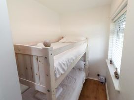 A bedroom with a bunk bed and a window at Sunrise Cottage Beadnell