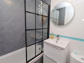 A bathroom with shower, bathtub, sink and toilet at Sunrise Cottage in Beadnell
