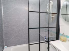 A bathroom with a shower and bathtub at Sunrise Cottage Beadnell