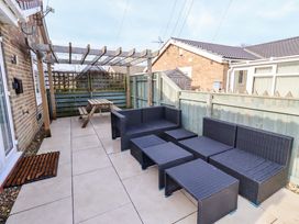 An outdoor patio with seating and a table at Sunrise Cottage Beadnell