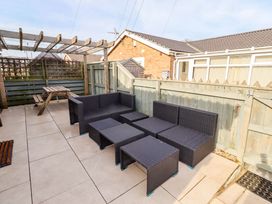 A garden patio with an outdoor seating set and a picnic table at Sunrise Cottage Beadnell
