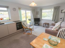 A living room with a sofa and kitchen area at Bre An Mor, Praa Sands
