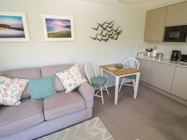 A living area with a sofa and dining table at Bre An Mor in Praa Sands
