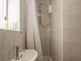 A shower area with a shower head and soap dispenser at Bre An Mor in Praa Sands