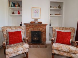 A sitting room with two armchairs and a fireplace at Penrose Farm Cottage St Keverne