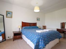 A bedroom with a bed and bedside table at Penrose Farm Cottage St Keverne