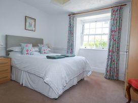 A bedroom with a bed and decorative pillows at Penrose Farm Cottage St Keverne