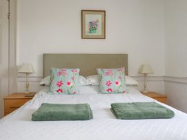 A bedroom with a bed, pillows, and a lamp at Penrose Farm Cottage St Keverne